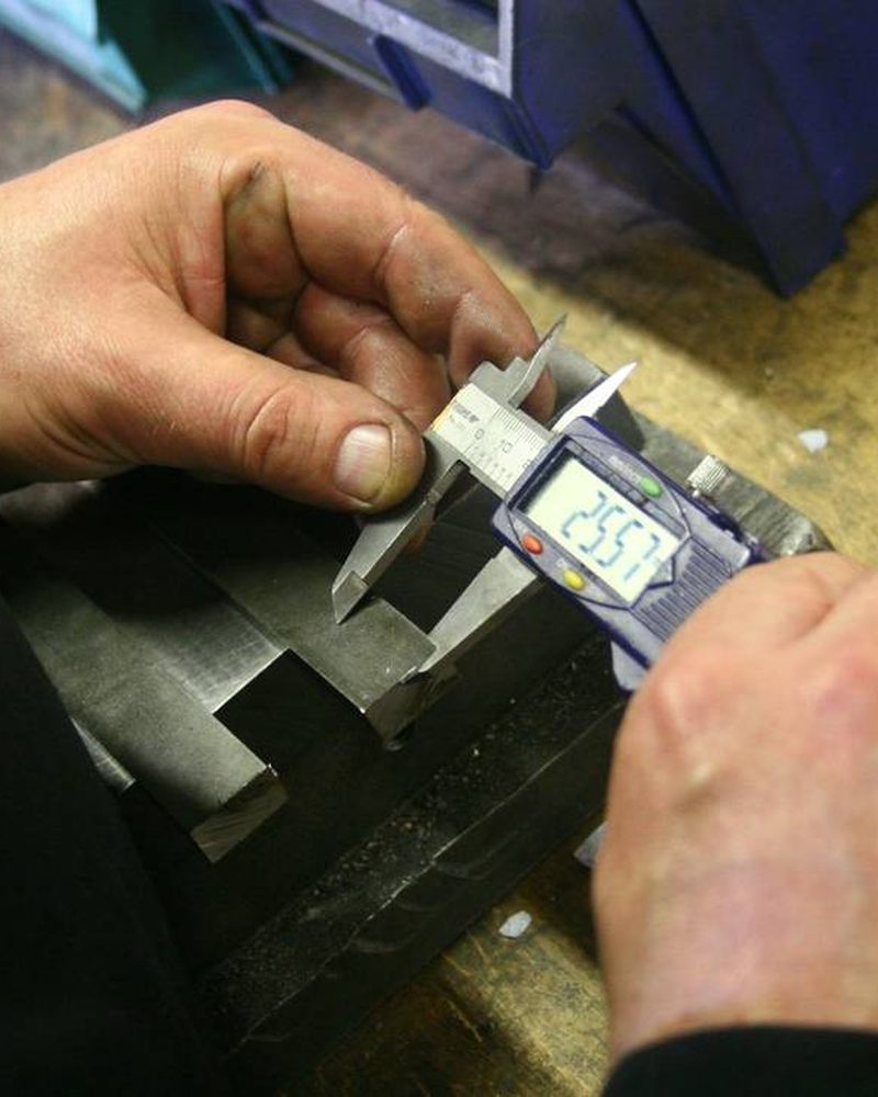 Mesure d'une pièce au pied à coulisse pendant un contrôle qualité